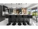 Modern kitchen with black cabinetry, a center island with seating, pendant lighting, and large windows at 14412 Saint Georges Hill Dr, Orlando, FL 32828