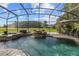 Screened-in pool with a waterfall feature and ample seating at 14412 Saint Georges Hill Dr, Orlando, FL 32828