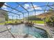Inviting pool with waterfall, spa, and screened-in enclosure at 14412 Saint Georges Hill Dr, Orlando, FL 32828