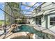 Screened-in pool area with waterfall feature, spa, patio, and lush landscaping at 14412 Saint Georges Hill Dr, Orlando, FL 32828