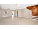 Open-concept living room with wood stairs, light-colored tile flooring, and natural light at 1614 Shady Ridge Ct # 252, Orlando, FL 32807