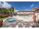 Community pool and spa surrounded by lounge chairs, mature landscaping, and community buildings at 1614 Shady Ridge Ct # 252, Orlando, FL 32807