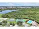 Aerial view highlighting community amenities including a pool, tennis courts, and a lake at 168 Club Villas Ln, Kissimmee, FL 34744