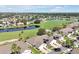 Overhead view of homes next to a golf course and blue lake in a lush green neighborhood at 168 Club Villas Ln, Kissimmee, FL 34744
