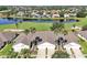 Aerial view featuring a nice neighborhood with golf course, lake and palm tree lined street at 168 Club Villas Ln, Kissimmee, FL 34744