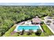 Aerial view showcasing a pool, clubhouse, and community amenities surrounded by lush greenery at 168 Club Villas Ln, Kissimmee, FL 34744