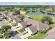Aerial view overlooking homes with golf course and lake, and palm trees on the property at 168 Club Villas Ln, Kissimmee, FL 34744
