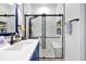 This bathroom features a sleek vanity and a modern glass-enclosed shower with white and blue patterned tile at 168 Club Villas Ln, Kissimmee, FL 34744