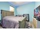 This bedroom features light blue walls, wood-look flooring, and a large bed, creating a cozy and inviting space at 168 Club Villas Ln, Kissimmee, FL 34744