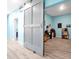 Light blue bedroom features a sliding barn door leading to an office space with natural light and storage at 168 Club Villas Ln, Kissimmee, FL 34744