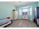 Bright bedroom with large bay windows overlooking the exterior, complemented by wood-look floors and soft blue walls at 168 Club Villas Ln, Kissimmee, FL 34744
