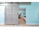 Bedroom features a rustic sliding barn door and light blue walls at 168 Club Villas Ln, Kissimmee, FL 34744