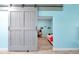 Bedroom features a rustic sliding barn door and light blue walls at 168 Club Villas Ln, Kissimmee, FL 34744