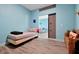 Light blue bedroom features a bed and a view into the living room via sliding doors at 168 Club Villas Ln, Kissimmee, FL 34744