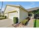 Charming one-story home with attached garage showcasing a well-maintained yard with decorative landscaping at 168 Club Villas Ln, Kissimmee, FL 34744