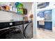 Convenient laundry room with modern washer/dryer units and storage shelves, next to the kitchen at 168 Club Villas Ln, Kissimmee, FL 34744