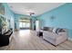 Bright living room featuring hardwood floors, comfortable seating, and sliding glass doors to the lanai at 168 Club Villas Ln, Kissimmee, FL 34744