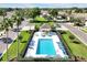 Aerial view of a community pool featuring lounge chairs and a covered picnic area with tables and chairs at 168 Club Villas Ln, Kissimmee, FL 34744