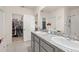 Well-lit bathroom featuring a double-sink vanity with a view into an organized walk-in closet at 176 Sofia Ln, Lake Alfred, FL 33850