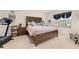 Bedroom featuring a dark wooden bed, a comfortable chair, and a treadmill fitness machine at 176 Sofia Ln, Lake Alfred, FL 33850