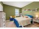 Stylish bedroom with blue bed frame, plush pillows, bench, and white dresser offering comfortable and appealing space at 176 Sofia Ln, Lake Alfred, FL 33850