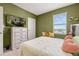 Bright bedroom featuring cozy bed, white dresser, and large TV, creating a comfortable and stylish space at 176 Sofia Ln, Lake Alfred, FL 33850