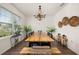 Spacious dining room with wood flooring, a beaded chandelier and a large window for natural light at 176 Sofia Ln, Lake Alfred, FL 33850