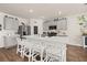 Open kitchen features a large island with seating, stainless appliances, gray cabinets and wooden floors at 176 Sofia Ln, Lake Alfred, FL 33850