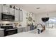 Bright kitchen featuring stainless steel appliances, gray cabinetry, and a sink overlooking the backyard at 176 Sofia Ln, Lake Alfred, FL 33850
