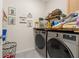Functional laundry room featuring modern washer and dryer, along with organized shelving for storage at 176 Sofia Ln, Lake Alfred, FL 33850