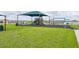 Community playground with swings and slides under a shade covering at 176 Sofia Ln, Lake Alfred, FL 33850