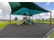 Community playground with slides and swings under a shade covering at 176 Sofia Ln, Lake Alfred, FL 33850