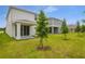 Exterior of home features white siding, manicured lawn and covered patio at 208 Flag Lilly Ln, Umatilla, FL 32784