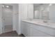 Bathroom featuring double sinks, white cabinets, and walk in closet at 208 Flag Lilly Ln, Umatilla, FL 32784