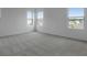 Bedroom featuring neutral carpet, three bright windows, and white walls at 208 Flag Lilly Ln, Umatilla, FL 32784
