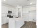 Modern white kitchen featuring a center island, stainless steel appliances, and ample storage at 208 Flag Lilly Ln, Umatilla, FL 32784