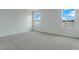 Bright and airy bedroom featuring neutral carpet and two windows that provide natural light at 212 Flag Lilly Ln, Umatilla, FL 32784