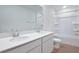Bright bathroom with double sinks, white cabinets, and a shower-tub combo at 216 Flag Lilly Ln, Umatilla, FL 32784