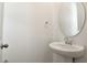 Powder bath featuring a pedestal sink, oval mirror, and towel ring at 216 Flag Lilly Ln, Umatilla, FL 32784