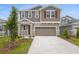 Inviting two-story home with a neutral color scheme, stone accents, and well-manicured landscaping at 216 Flag Lilly Ln, Umatilla, FL 32784