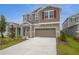 Inviting two-story home with a neutral color scheme, stone accents, and well-manicured landscaping at 216 Flag Lilly Ln, Umatilla, FL 32784
