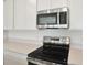 Close-up of a modern kitchen with stainless steel microwave, electric range, and bright counter tops at 216 Flag Lilly Ln, Umatilla, FL 32784