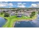 Aerial view of a home with a screened-in pool surrounded by lush landscaping near a pond at 2255 Stone Lake Ct, Orlando, FL 32824