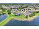 Aerial view of a neighborhood with manicured lawns, backyard pools, and a nearby pond at 2255 Stone Lake Ct, Orlando, FL 32824