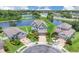 Aerial view of a two-story home near a pond with lush landscaping and a brick driveway at 2255 Stone Lake Ct, Orlando, FL 32824