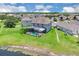 Aerial view of a home with a screened lanai with pool and lush landscaping near a pond at 2255 Stone Lake Ct, Orlando, FL 32824