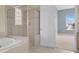 Bathroom showcasing a soaking tub, glass enclosed shower, and a view into an adjacent bedroom at 2255 Stone Lake Ct, Orlando, FL 32824