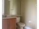 A modest bathroom featuring a vanity with sink, toilet, and a mirrored wall at 2255 Stone Lake Ct, Orlando, FL 32824