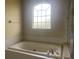 Bright bathroom featuring a large soaking tub under a sunny window and tile surround at 2255 Stone Lake Ct, Orlando, FL 32824