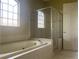 Bright bathroom featuring a glass shower and a soaking tub under a sunny window at 2255 Stone Lake Ct, Orlando, FL 32824